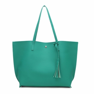Detail view of large mint green tote bag featuring lychee grain texture and tassel charm