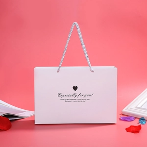 Elegant white gift bag with silver rope handles and heart motif for jewelry box
