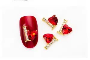 Macro shot of 3D alloy nail charm with red heart crystal and letter L embellishment