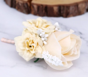 Detail of a champagne artificial rose boutonniere with silk petals on marble surface
