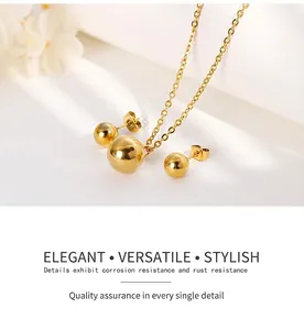 Macro detail of polished gold bead pendant necklace and matching ball stud earrings set