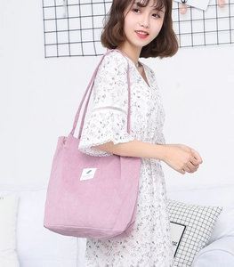 Detail of soft purple corduroy tote bag featuring striped texture and a white woven label