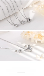Macro view of silver bead necklaces and matching stud earrings on minimalist background