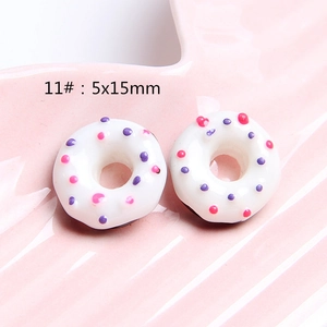 Macro view of white resin donut charms with pink dots for DIY crafts 5x15mm