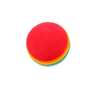 Gros plan d'une balle de jeu en mousse rayée arc-en-ciel pour chats colorés