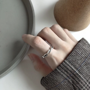 Detailed view of 925 sterling silver woven ring styled with a minimalist dark blazer