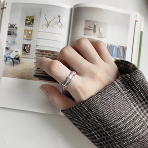 Detail of layered S925 silver ring with zircon stones worn by model in stylish setting