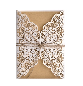 Detail of laser-cut lace wedding invitation with kraft paper liner and twine bow