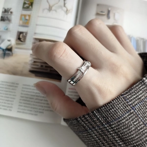 Macro view of a silver nail ring featuring sparkling crystals worn on a model hand