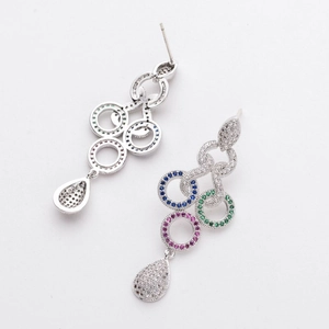 Macro shot of silver tassel earrings with colorful zircons and drop-shaped crystal pendants