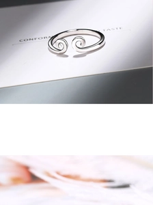 Macro detail of silver spiral ring on white card showing smooth metallic texture