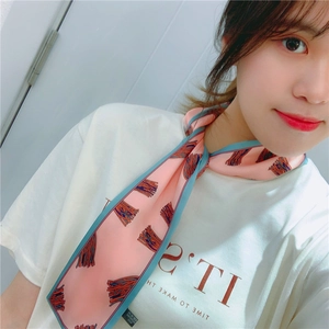 Detail of pink and blue silk-like neck scarf with colorful fringe pattern on model