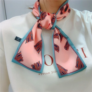 Detail of pink floral neck scarf with blue trim tied in a stylish bow on model