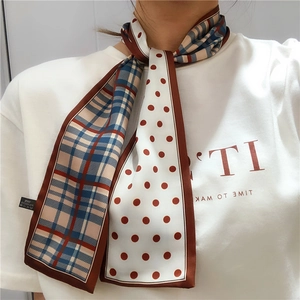Detail showing double-sided scarf with plaid and polka dot patterns on a model neck