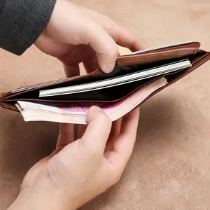 Détail d'un portefeuille en cuir marron avec deux compartiments à billets et coutures