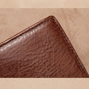 Gros plan sur les coutures renforcées et la texture de ce portefeuille en cuir marron