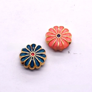 Detailed view of cloisonné alloy daisy charms in royal blue and pink with gold edges
