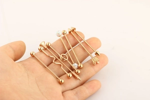 Detailed collection of rose gold industrial barbells with arrow and twisted designs