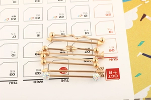 Set of six rose gold industrial barbells with crystals and diverse geometric spiral shapes