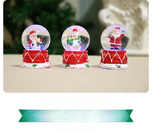 Detailed close-up of resin Santa Claus and Snowman inside Christmas snow globes