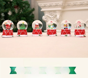 Close-up of six mini Christmas snow globes featuring Santa, snowmen and holiday trees