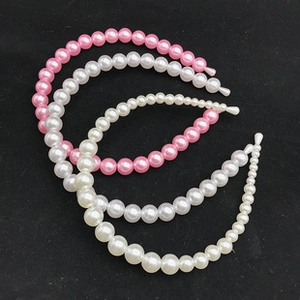 Detail of handmade oversized pearl headbands in white and pink with gradient beads