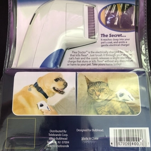 Electric flea comb for pets in retail blister packaging with purple metal teeth