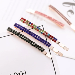 Detailed close-up of rose gold bobby pins set with multi-color sparkling rhinestones