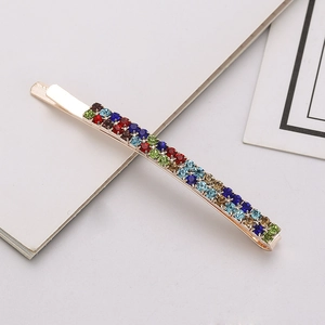 Detailed view of golden hairpin with three rows of multi-colored sparkling rhinestones