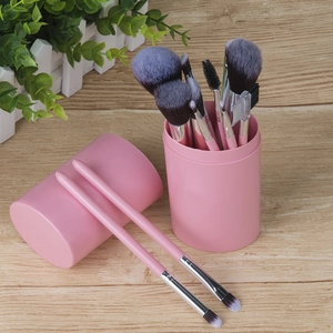 12pcs pink makeup brush set with storage cylinder on wooden table background