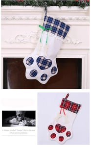 Detail of red and blue plaid dog paw Christmas stockings with bone tags by fireplace
