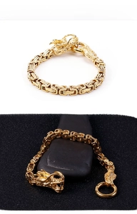 Macro shot of gold dragon head clasp and Byzantine weave on men's stainless steel bracelet