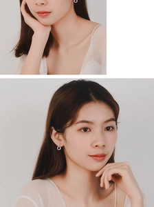 Close-up of elegant silver hoop earrings worn by a model in a minimalist portrait