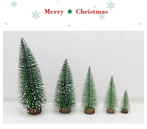 Detail of five mini pine needle Christmas trees with snow tips on wooden bases
