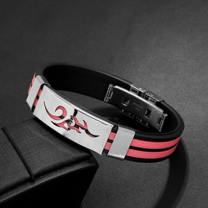 Close-up of stainless steel men's bracelet featuring tribal pattern and red silicone details
