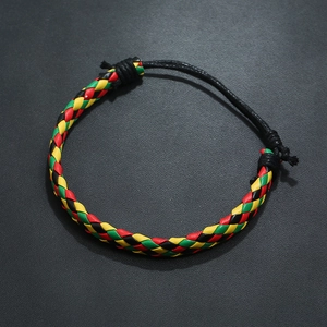 Detail of colorful woven adjustable leather bracelet in red yellow and green reggae colors