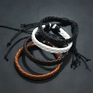 Close-up of braided leather bracelets in black, white and brown with adjustable pull cords