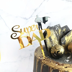 Detailed close-up of a gold mirror acrylic Super DAD cake topper with superhero silhouette