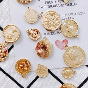 Flat lay of vintage gold-plated coin pendants with embossed Elizabeth II portrait and texture