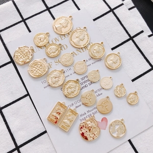 Flat lay of retro gold coin pendants featuring Queen Elizabeth II and Venus portrait designs