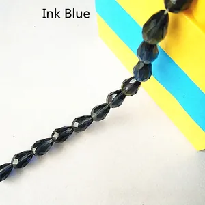 Detailed view of faceted ink blue teardrop glass beads for DIY jewelry and crafts