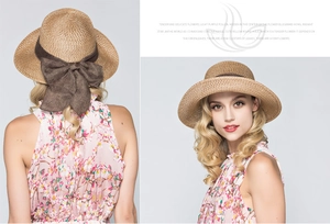 Detail of straw sun hat with large dark brown bow ribbon and textured natural weave