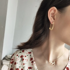 Close-up of golden irregular butterfly earrings and matching necklace set on model
