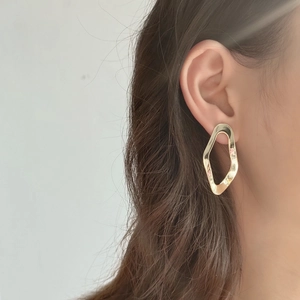 Minimalist gold irregular geometric earrings worn by model for elegant style