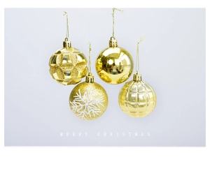 Detail of four gold Christmas baubles with snowflake patterns and glitter finishes
