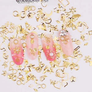 Golden nail art charms set with stars, moon, and heart shapes on a white background