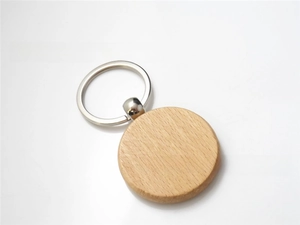 Close-up of circular beech wood keychain with natural grain and silver metal ring