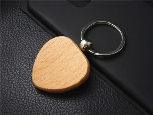 Close-up of heart shaped beech wood keychain with silver metal ring on black leather