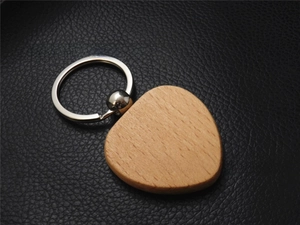 Macro detail of beech wood keychain with vertical grain on black leather background