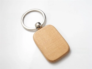 Detail of a rectangular beech wood keychain with smooth rounded corners and silver metal ring